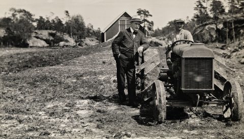 Knut_Hamsun_1859-1952_ved_siden_av_en_uidentifisert_mann_på_traktor_juni_1929