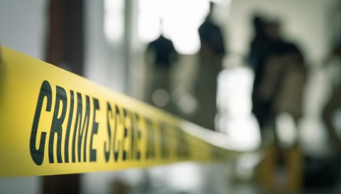 crime scene tape with blurred forensic in cinematic tone
